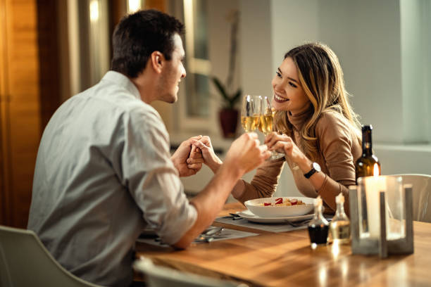 Man on a date with a woman doing a champagne toast at dinner