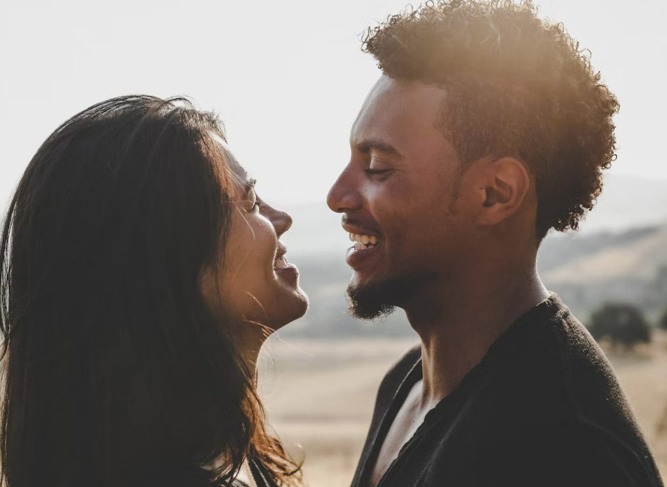 girl gazing at guy lovingly with sunset in the background