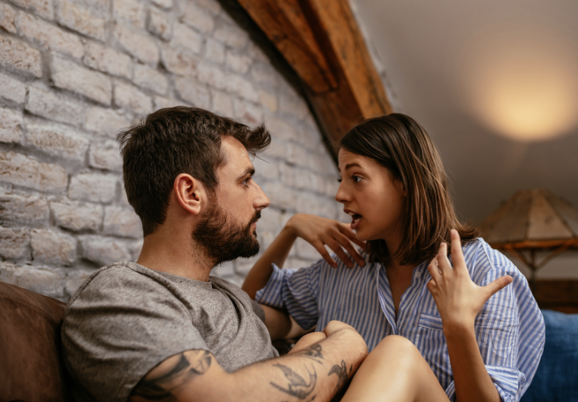 Man having conversation with woman on the couch.