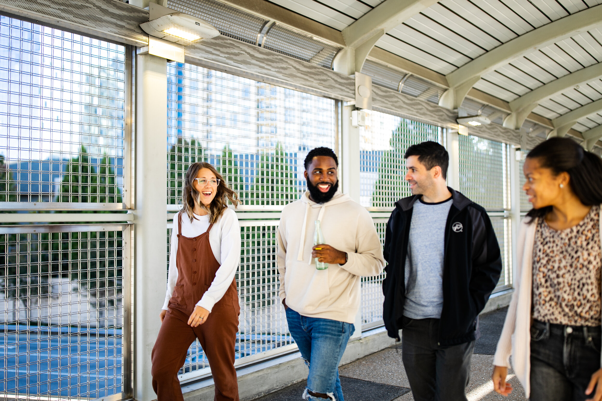 Two single men and two single women having an active conversation while walking on a bridge.