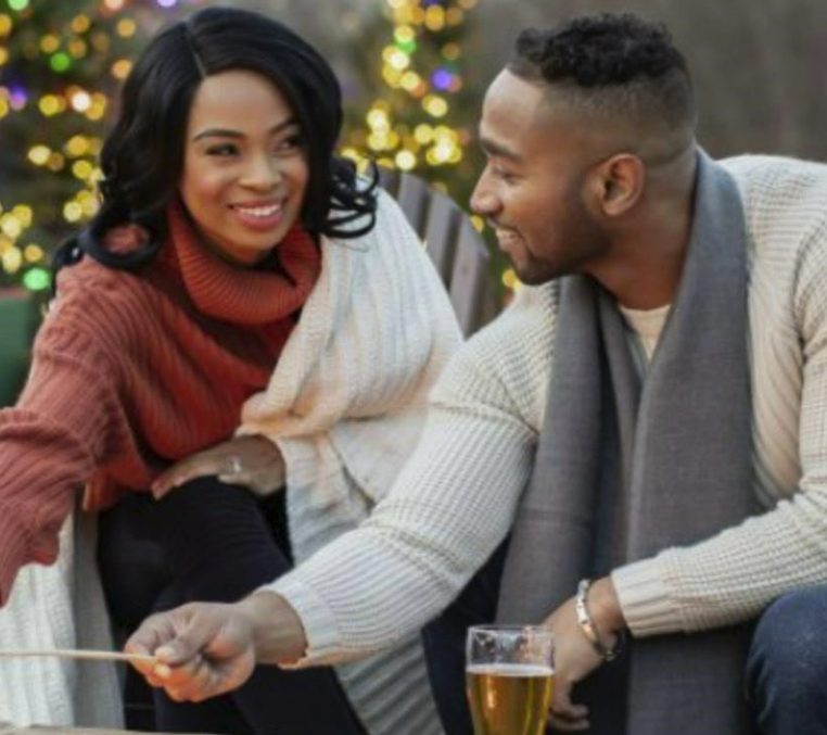Atlanta_Holiday_Cover lovely couple sitting by the bonfire roasting marshmallows with christmas trees in the background.