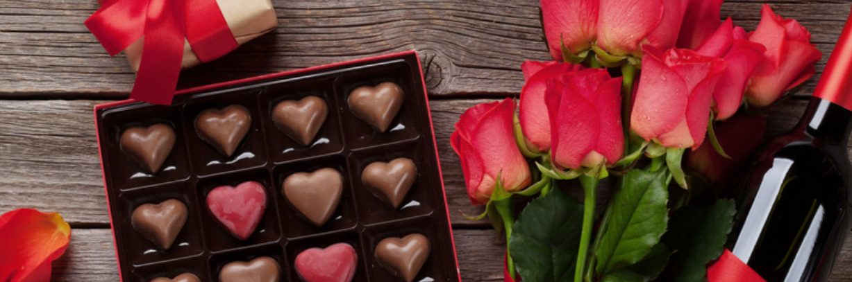 Romantic gift of heart shaped chocolates with a bouquet of roses. 