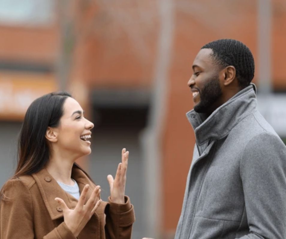 Couple talking & listening to each other while smiling. 